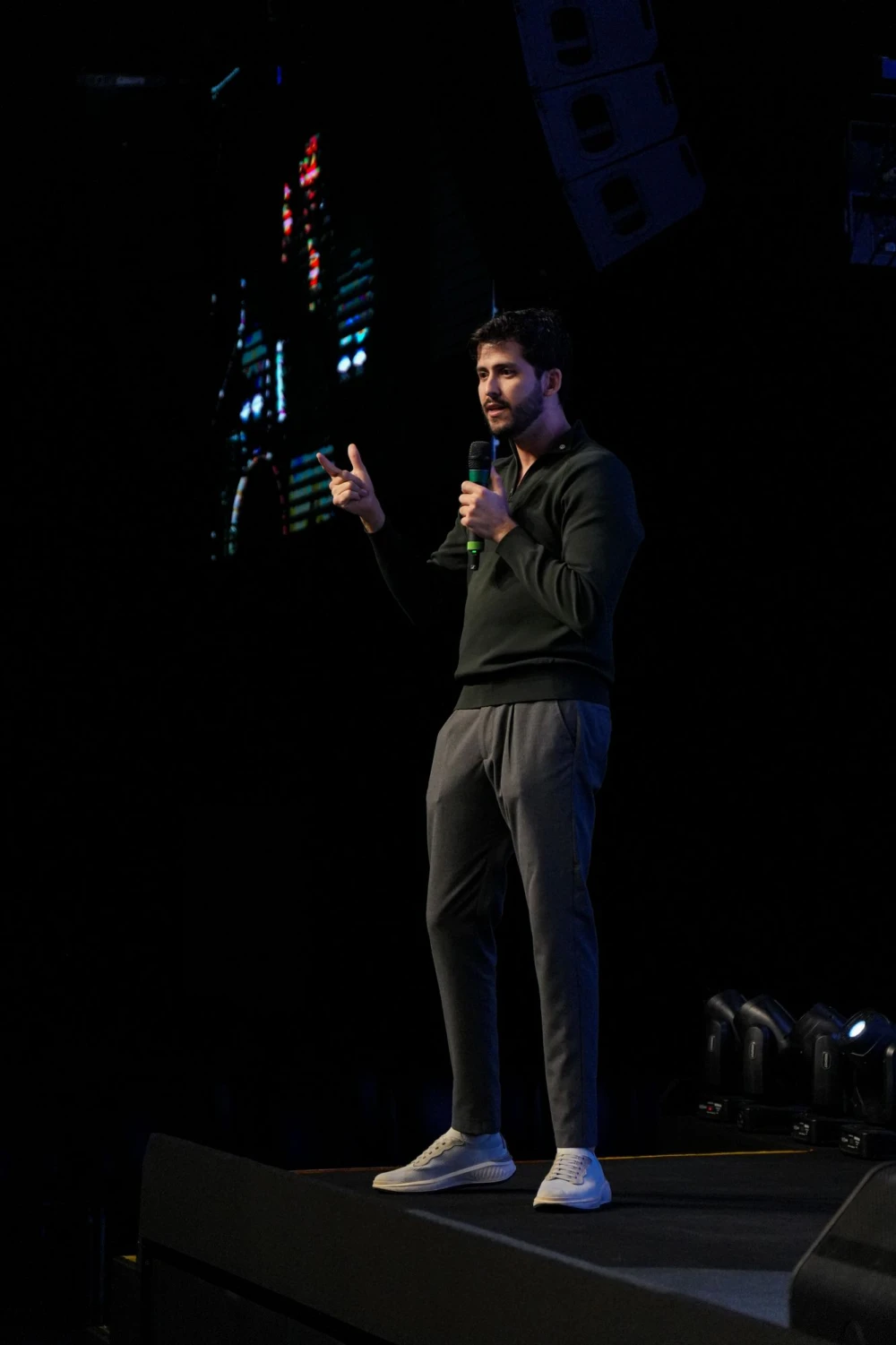 JP falando no palco, com um microfone na mão